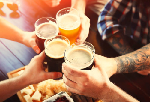 Group of friends toasting with beer in pub, closeup. Banner design